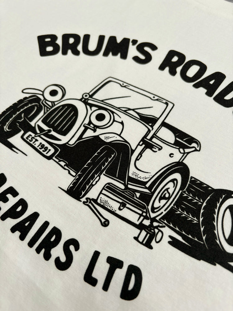 A close up shot of our 90s TV Show Brum inspired T-shirt design featuring a car with eyes in a car workshop